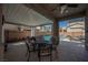 Covered outdoor patio area with dining set, curtains, and view of the pool at 3717 Moonshine Falls Ave, North Las Vegas, NV 89085