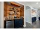 Charming wet bar featuring custom wood walls, shelves, mini-fridge and colorful tile at 3717 Moonshine Falls Ave, North Las Vegas, NV 89085