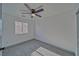 This bedroom features neutral carpeting, a ceiling fan, and a window providing natural light at 384 E Erin St # 3, Pahrump, NV 89048
