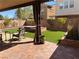 Cozy backyard with green artificial turf, brick patio, and relaxing seating area with shade and a hot tub at 384 Gracious Way, Henderson, NV 89011