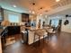 Open-concept kitchen with a granite countertop island, stainless steel appliances, and hardwood floors at 384 Gracious Way, Henderson, NV 89011
