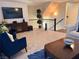 Bright living room showcasing comfortable seating, a large TV, and a modern staircase at 384 Gracious Way, Henderson, NV 89011