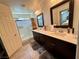 This bathroom has dual sinks, dark cabinets, framed mirrors, and a walk-in shower at 384 Gracious Way, Henderson, NV 89011