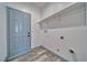 Functional laundry room with built-in shelving and modern gray door to the exterior at 388 E Erin St # 4, Pahrump, NV 89048