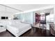 Chic bedroom with a king bed, dark wood floors, a unique modern kitchen with a breakfast bar in the background at 4381 W Flamingo Rd # 2504, Las Vegas, NV 89103