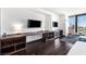 Comfortable living area featuring a sleek desk, TV, and floor to ceiling window with a striking city view at 4381 W Flamingo Rd # 2504, Las Vegas, NV 89103