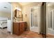 Bathroom with a wooden vanity, large mirror, and tiled shower at 4726 Idaho Ave, Las Vegas, NV 89104