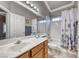 Bright bathroom with a white vanity top, wood cabinets, and shower over tub at 511 Beaconwood St, Henderson, NV 89052