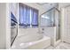 Bathroom features a soaking tub with a shower and modern fixtures at 511 Beaconwood St, Henderson, NV 89052