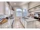 Bright kitchen with stainless steel sink, granite countertops, an island, and views of a dining and living area at 511 Beaconwood St, Henderson, NV 89052