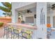 Inviting outdoor kitchen bar with seating and a ceiling fan for relaxing entertainment at 511 Beaconwood St, Henderson, NV 89052