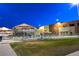 Outdoor swimming pool at night with colorful umbrellas, poolside seating, and a recreational slide for water fun at 511 Beaconwood St, Henderson, NV 89052
