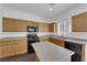 Modern kitchen features black appliances, wood cabinets, and center island at 5124 Veeder Crest St, North Las Vegas, NV 89081