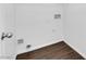 A bright laundry room featuring dark hardwood floors at 5124 Veeder Crest St, North Las Vegas, NV 89081