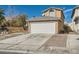 Two-story home featuring a two-car garage with white door and concrete driveway at 5310 Plainfield Dr, Las Vegas, NV 89142