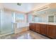 Bright bathroom with double vanity, soaking tub, and walk-in shower at 63 Crescent Palm Ct, Henderson, NV 89002