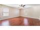 Bright bedroom featuring wood floors, two windows, and a ceiling fan with light at 63 Crescent Palm Ct, Henderson, NV 89002