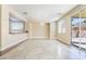 Open-concept living room with elegant light fixture, neutral paint and sliding glass door at 63 Crescent Palm Ct, Henderson, NV 89002