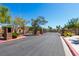 View of community entrance with gate, landscaping and trees at 6493 Za Zu Pitts Ave # 101, Las Vegas, NV 89122