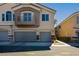 Exterior view of two-story home featuring multi-car garages, balcony and neutral toned stucco at 6493 Za Zu Pitts Ave # 101, Las Vegas, NV 89122