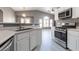 Well-lit kitchen features white cabinets, stainless steel appliances, and view of adjacent living area at 6493 Za Zu Pitts Ave # 101, Las Vegas, NV 89122