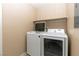 Bright laundry room with white washer and dryer and shelf above at 6493 Za Zu Pitts Ave # 101, Las Vegas, NV 89122