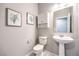 Stylish half bathroom featuring a pedestal sink, matching botanical prints and a modern white vanity for extra storage at 6637 Rockhouse St, North Las Vegas, NV 89086