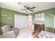 Charming Bedroom with carpet flooring, ceiling fan, crib, glider and a bright window at 6637 Rockhouse St, North Las Vegas, NV 89086