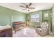 Charming Bedroom with carpet flooring, ceiling fan, crib, glider and a bright window at 6637 Rockhouse St, North Las Vegas, NV 89086