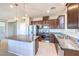 Elegant kitchen featuring granite countertops, stainless steel appliances, dark wood cabinets, and a central island at 6637 Rockhouse St, North Las Vegas, NV 89086