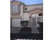 Inviting two-story home with stucco siding, a covered entry, attached garage and mature landscaping at 6965 Coral Rock Dr, Las Vegas, NV 89108