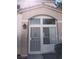Covered front entry featuring a security door and adjacent window, with a porch light fixture at 6965 Coral Rock Dr, Las Vegas, NV 89108