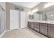 Bright bathroom with double vanity, modern fixtures, and a glass-enclosed shower with tiled walls at 71 Gosia Grove Ave, North Las Vegas, NV 89031