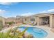 Backyard pool with rock feature, lounge chairs, and covered patio seating at 71 Gosia Grove Ave, North Las Vegas, NV 89031
