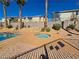 Community hot tub next to pool with desert landscaping, gated fencing, and nearby lounging at 7563 Violet Vista Ave # 201, Las Vegas, NV 89130