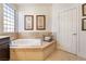 Close-up of soaking tub with tile surround, neutral walls, and natural light from a window at 837 Roseberry Dr, Las Vegas, NV 89138