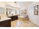 Luxurious bathroom featuring dual vanities, a soaking tub, and neutral tile at 837 Roseberry Dr, Las Vegas, NV 89138