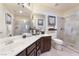 Elegant bathroom with a double vanity, large mirror, and a glass-enclosed shower with tile accents at 837 Roseberry Dr, Las Vegas, NV 89138