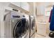 Convenient laundry room with front loading washer and dryer, sink, and built-in storage cabinets at 837 Roseberry Dr, Las Vegas, NV 89138