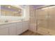 Bathroom featuring dual sink vanity, modern mirror, and glass-enclosed shower at 8446 Vacarez Dr, Las Vegas, NV 89149
