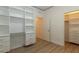 Bedroom with a built-in desk, shelving, and walk-in closet. Finished with light colored wood-look floors at 8446 Vacarez Dr, Las Vegas, NV 89149