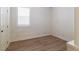 Neutral bedroom with a large shuttered window and wood-look floors at 8446 Vacarez Dr, Las Vegas, NV 89149