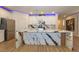 Modern kitchen featuring a large island with a unique marbled countertop and stainless steel appliances at 8446 Vacarez Dr, Las Vegas, NV 89149