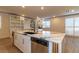 Kitchen island with a sink and dishwasher, featuring white cabinets and a marbled countertop at 8446 Vacarez Dr, Las Vegas, NV 89149