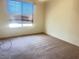 Standard bedroom with neutral carpet, large window and plain walls at 9299 Adamshurst Ave, Las Vegas, NV 89148