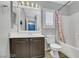 Well-lit bathroom with wood-look flooring, white cabinets, and a shower-tub combination at 10218 Maltese Cross Ct, Las Vegas, NV 89183