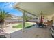 Enjoy outdoor living under this covered patio with ample seating, mature trees, and artificial turf at 10218 Maltese Cross Ct, Las Vegas, NV 89183