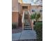 Inviting condo exterior featuring a staircase leading to a charming second-story entrance and desert landscaping at 10525 Autumn Pine Ave # 203, Las Vegas, NV 89144