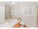 Bright bathroom featuring a large mirror, wood cabinets, and a window with plantation shutters at 11002 Inverlochy Ct, Las Vegas, NV 89141