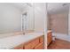 Bright bathroom featuring a tiled floor, large mirror, double vanity and a shower/tub combo at 11002 Inverlochy Ct, Las Vegas, NV 89141